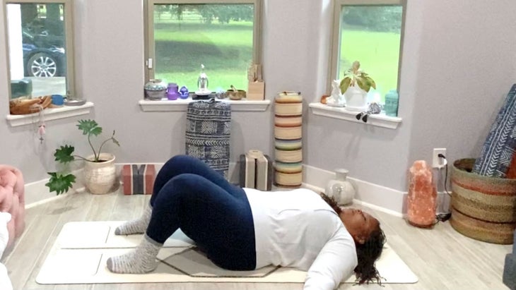 Tamika Caston-Miller lies in Constructive Rest Pose in a restorative yoga sequence