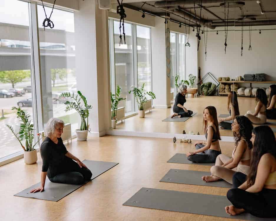 a yoga class with an elderly teacher and her 3 students